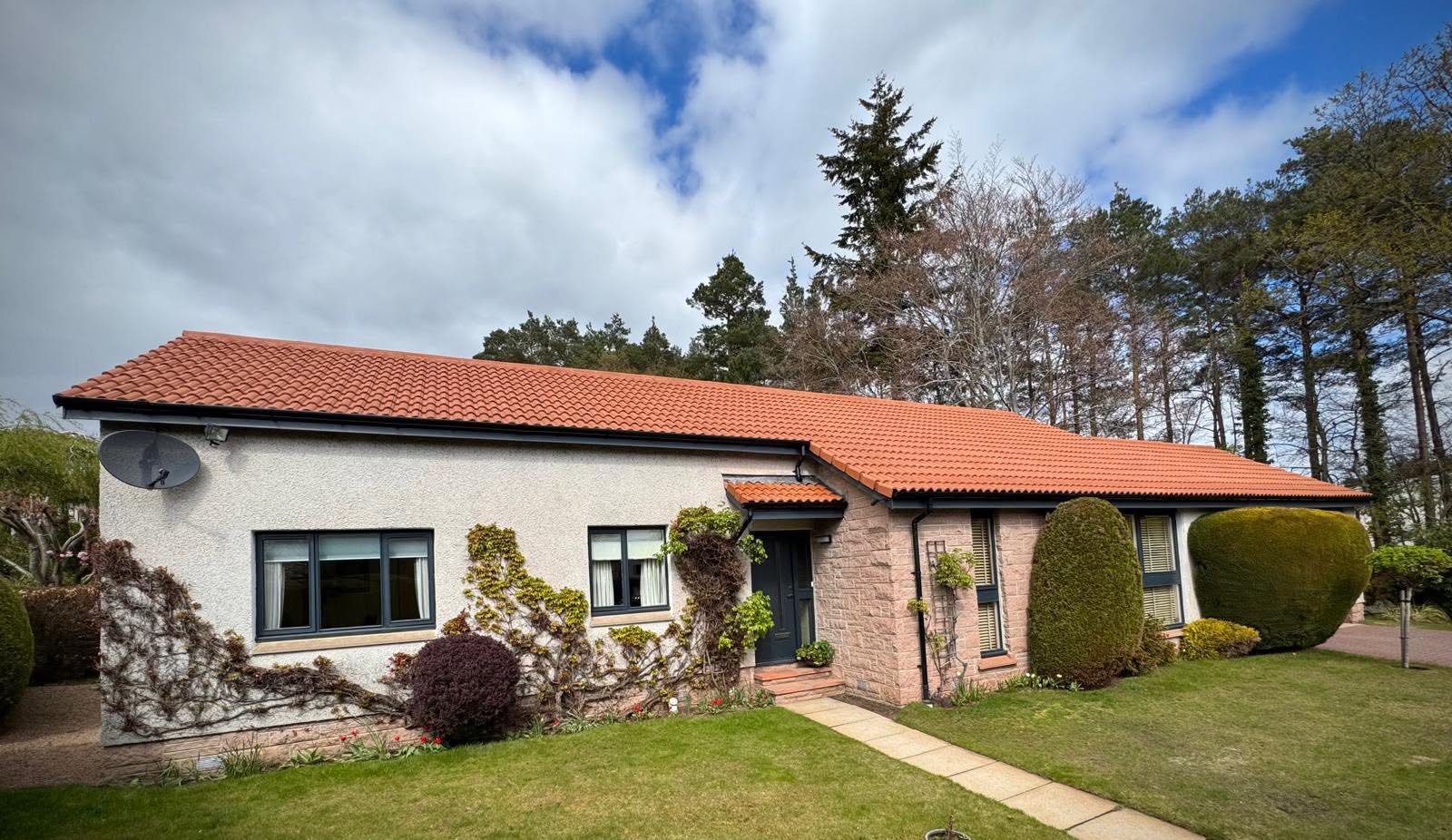 Bungalow with a freshly cleaned roof under a dramatic Aberdeen sky