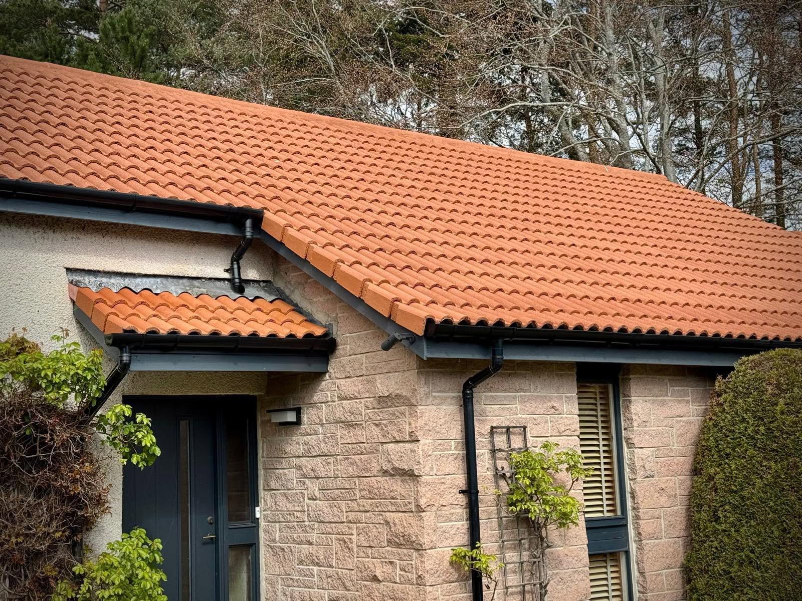 Close-up of cleaned terracotta roof tiles on a stone house